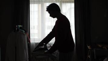 A man ironing trousers clothes in a room. trousers video