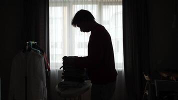 A man ironing clothes in a room video