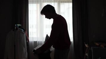 A man standing in front of a window with a laptop video