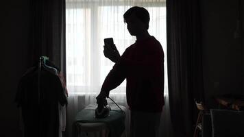 A man is ironing in front of a window video