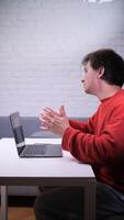 A man sitting at a table with his hands up video