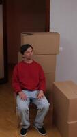 A man sitting on a chair in front of boxes video