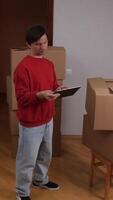 A man standing in front of boxes with a tablet video