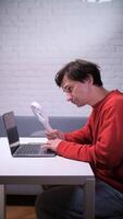 A man is looking at a laptop while sitting at a table video