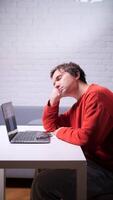 A man is sleeping on a laptop while sitting at a table video