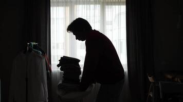A silhouette of a man standing in front of a window video