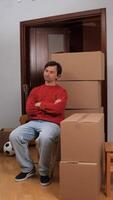 man sitting on a chair with cardboard boxes video