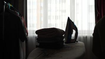 silhouette man ironing clothes, window with a curtain video