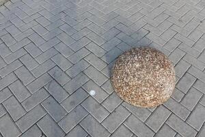An Artistic and Abstract Representation of a Round Stone Placed on a Paved Surface photo