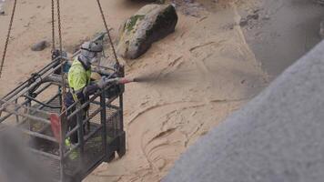 Spraying concrete on seaside cliff for stabilization video