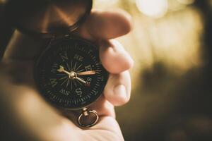 Holding a Compass While Exploring Nature in a Forest During Golden Hour photo