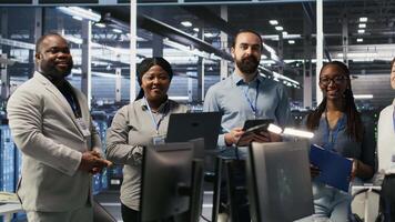 Happy data center engineering team members collaborating on neural network software development. Smiling server hub coworkers implementing machine learning technology in workplace, camera A video