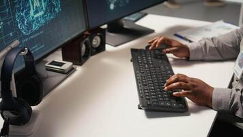 Close up of data center admin coding on PC, doing software updates for AI mainframes. Server farm IT professional typing on computer keyboard, optimizing infrastructure, camera A video