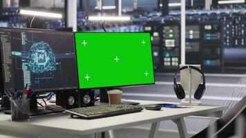 Green screen desktop PC set up in data center overseeing server infrastructure powering artificial intelligence workflows. Chroma key displays used for monitoring backend systems video