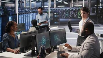 Happy data center manager providing positive feedback to engineer developing neural networks software on computer. Cheerful supervisor pleased by employee work implementing AI in server room, camera A video