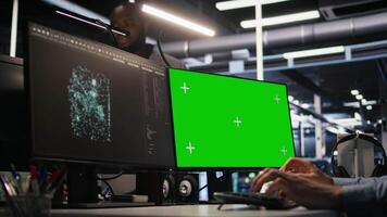Close up of data center technician using green screen PC to monitor neural network AI. Server room worker using chroma key computer to oversee rigs powering machine learning processes, camera A video