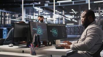 Joyous data center software developer delighted after solving all computer bugs. Smiling african american man in server hub pleased after finishing tasks on PC, overseeing server rigs, camera A video