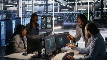 Server farm manager overseeing engineer examining neural network algorithms. Data center team leader and worker reviewing performance dashboards of artificial intelligence infrastructure, camera A video
