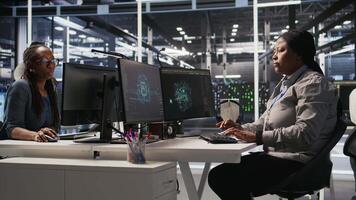 Data center developer coding on PC, doing software updates for AI supercomputers, looking at watch. Server farm IT professional optimizing infrastructure using artificial intelligence, camera A video