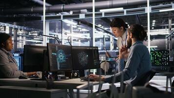 Data center admins working together, collaborating on neural network software development. Teamworking server hub colleagues implementing artificial intelligence technology in workplace, camera A video