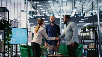Diverse business leaders greeting each other in a conference room, shaking hands and starting the negotiations for a new partnership deal. Powerful people discuss contract details. Camera A. video