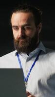 Vertical Programmer on data center platform using laptop to monitor neural network LLM visualization. Industrial server farm IT professional overseeing rigs powering machine learning processes video