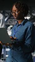 Vertical Data center engineer walking on industrial platform, running diagnostics on equipment to identify errors. Server farm IT professionals preventing rigs failure to minimize downtime, camera B video