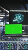 Vertical Isolated screen laptop next to elevated industrial data center control station display showing AI visualization. Chroma key notebook device in server farm displaying neural network diagnostics video