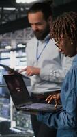 Vertical Data center software developer panicking after receiving critical error popup on laptop display. African american woman in server hub alerted by bugs causing low hardware performance, camera B video