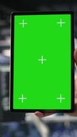 Vertical Close up of data center admin using mockup tablet to update storage arrays software, configuring network virtualization. Server room IT expert using chroma key device to verify settings, camera B video