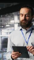 Vertical Computer scientists in data center monitoring neural network LLM visualization. Industrial server farm IT professionals overseeing rigs powering machine learning processes, camera B video