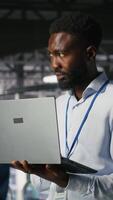 Vertical Server hub IT professional managing storage arrays supporting deep learning training workflows. Engineer on industrial platform performing maintenance on servers handling AI processing tasks, camera B video