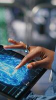 Vertical Close up of server farm admin using tablet to do infrastructure AI machine learning automatization. Data center software developer doing maintenance using artificial intelligence, camera B video