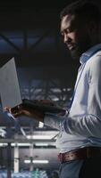 Vertical Technicians on data center industrial platform analyzing performance outputs after completing software updates. Server hub engineering team finetuning server rig configurations, camera A video