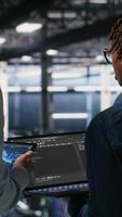Vertical Data center system administrators performing maintenance on supercomputers used for AI. Engineering team managing server hub rigs used for deep learning training, camera B video