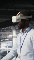 Vertical Engineer using VR headset in data center to update server tech, configuring equipment using software tools. Server hub employee reviewing hardware analytics using virtual reality, camera B video