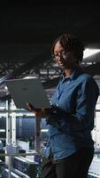 Vertical Data center software developers using devices to review AI LLM visualizations. IT professionals working together to analyze neural networks outputs, ensuring stable gear operations video