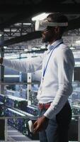 Vertical Data center programmers on industrial platform using virtual reality tech, collaborating on tasks. Server room IT professionals visualizing large language model architecture using VR headset video