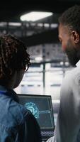 Vertical Data center team on industrial platform collaborating to maintain servers using artificial intelligence. Engineers cooperating to support infrastructure AI machine learning automatization, camera B video