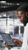 Vertical Data center programmers on industrial platform checking lines of code, collaborating on tasks. Server hub IT specialists visualizing large language model architecture using tablet and PC video