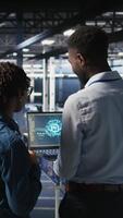 Vertical Data center team on industrial platform collaborating to maintain servers using artificial intelligence. Engineers cooperating to support infrastructure AI machine learning automatization, camera A video