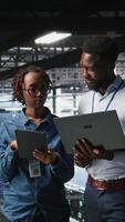 Vertical Data center admins running diagnostics on equipment using system monitoring tools to identify errors, doing brainstorming. IT experts work together to prevent failure and minimize downtime, camera A video