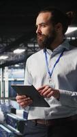 Vertical Server room technician next to coworkers reviewing neural network code and LLM visualization dashboards. Data center IT specialist next to colleagues monitoring AI system performance, camera A video