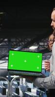 Vertical Military command center engineering team using chroma key notebook. Army IT expert and coworkers in data center using green screen laptop to defend networks against threats, camera A video