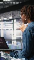 Vertical Worried workers trying to fix hacked infrastructure systems. Panicked engineers in data center react to ransomware warning on laptop screen, scrambling to launch emergency response protocol, camera B video