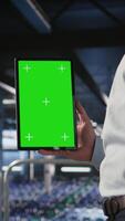 Vertical Close up of data center admin using mockup tablet to update storage arrays software, configuring network virtualization. Server room IT expert using chroma key device to verify settings, camera A video