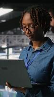 Vertical Portrait of joyful computer scientist in data center monitoring neural network LLM visualization. Upbeat woman in server farm overseeing rigs powering machine learning processes, camera B video