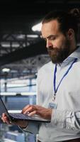 Vertical Server farm IT expert managing storage arrays supporting machine learning training workflows. Technician on industrial platform doing maintenance on rigs handling AI processing tasks, camera B video
