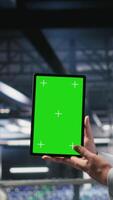 Vertical Military personnel overseeing AI computing operations on isolated screen tablet in high tech server facility. Army tech experts using chroma key device to oversee communication systems, camera B video