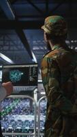 Vertical Military server room IT professionals using AI LLM tech on laptop to review network performance. Army operators manage hardware systems supporting mission critical connectivity, camera A video